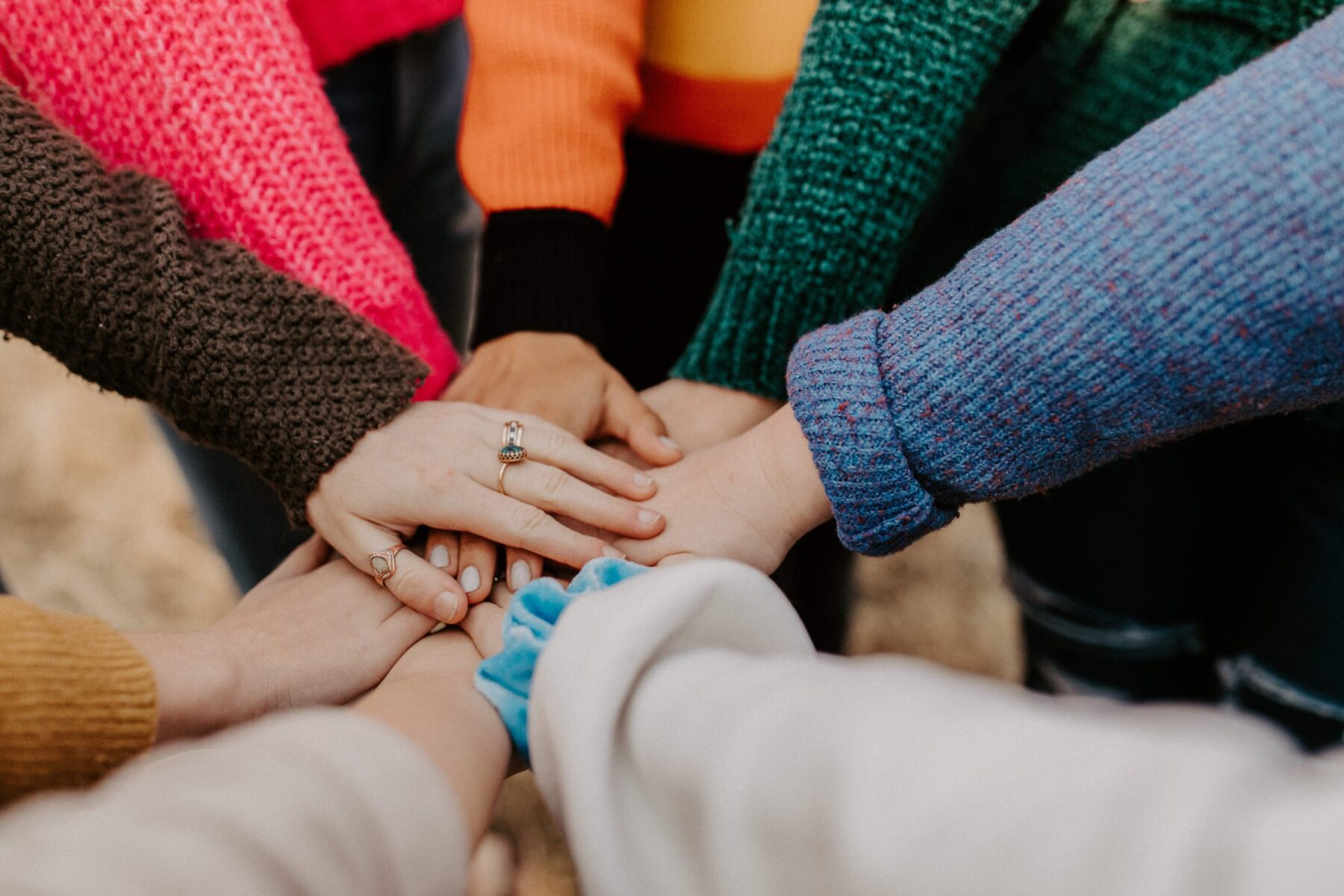 Group of people placing their hands together in a circle